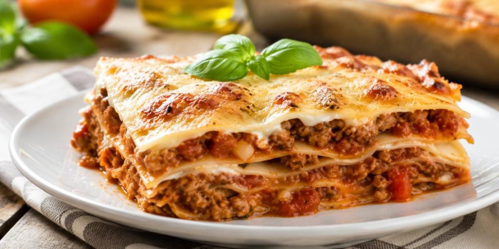 Porción de lasaña de carne casera gratinada con queso