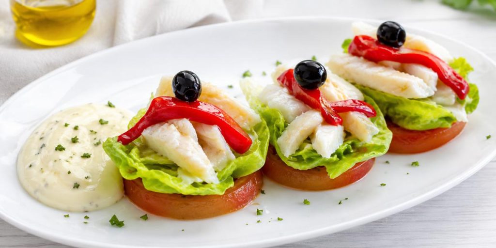 Cogollos de lechuga con bacalao, pimientos del piquillo y salsa alioli
