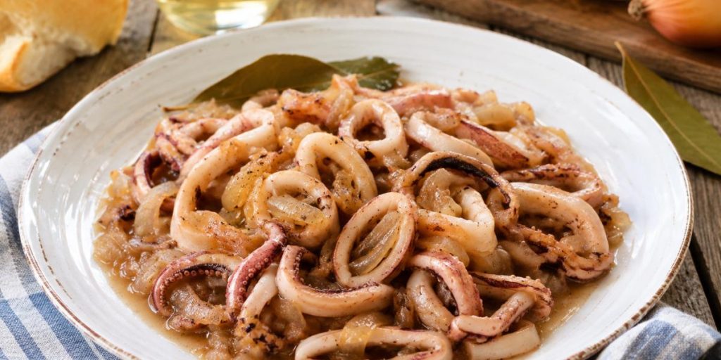 Plato de pota encebollada casera con cebolla pochada y salsa suave