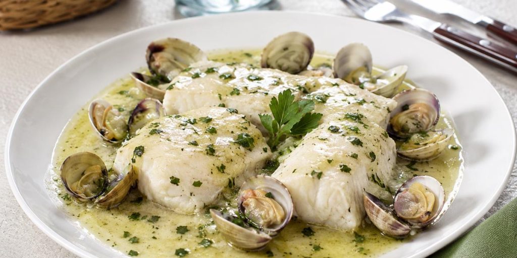 Lomos de merluza en salsa verde con almejas y perejil fresco