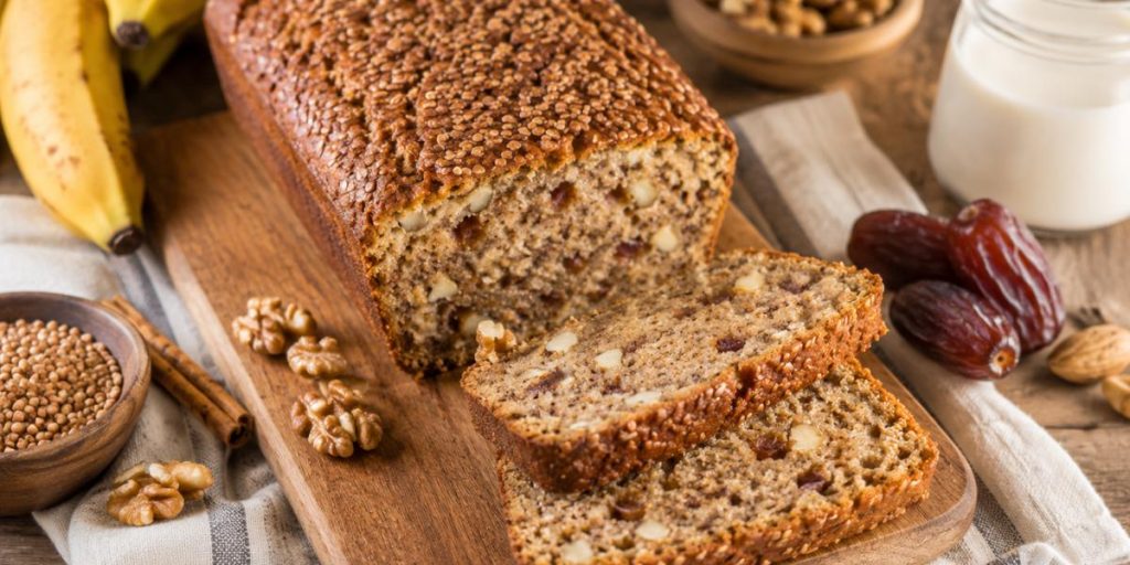 Bizcocho de trigo sarraceno con plátano, dátiles y nueces sobre tabla de madera
