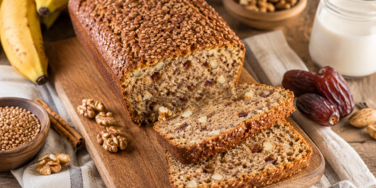Bizcocho de trigo sarraceno con plátano, dátiles y nueces sobre tabla de madera