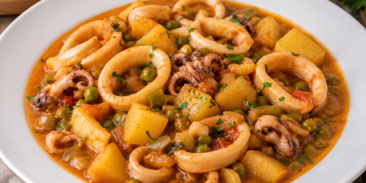Calamares guisados con patatas y guisantes en salsa tradicional