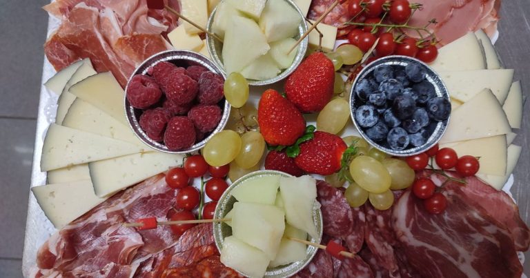 Tabla de embutidos con fresas, uvas y quesos